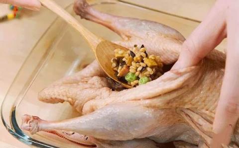 Nhồi hỗn hợp gạo vào trong bụng vịt, sau đó dùng kim chỉ khâu kín lại.